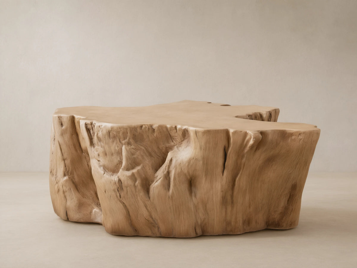 Root Outdoor Coffee Table, light brown concrete, sculpted like a tree root with textured sides, on a stone patio.