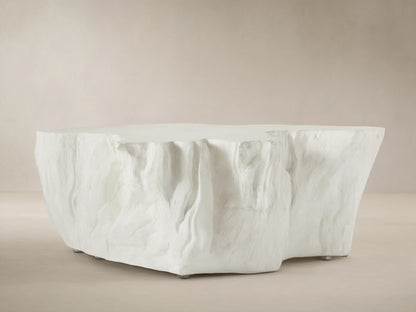 Bleached Root Outdoor Coffee Table, light concrete, organic shape, textured sides, flat top, on brick floor.