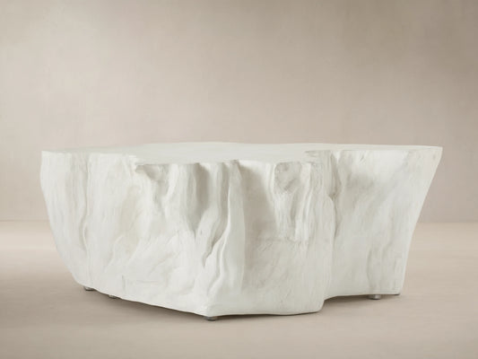 Bleached Root Outdoor Coffee Table, light concrete, organic shape, textured sides, flat top, on brick floor.