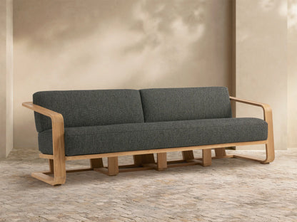 Sonoma Outdoor Teak Sofa: modern, light teak frame with dark gray cushions, two seats. Shown angled in an outdoor patio.