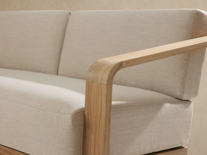 Sonoma Outdoor Teak Sofa: a two-seater with light beige fabric cushions and a natural, light-colored teak wood frame.