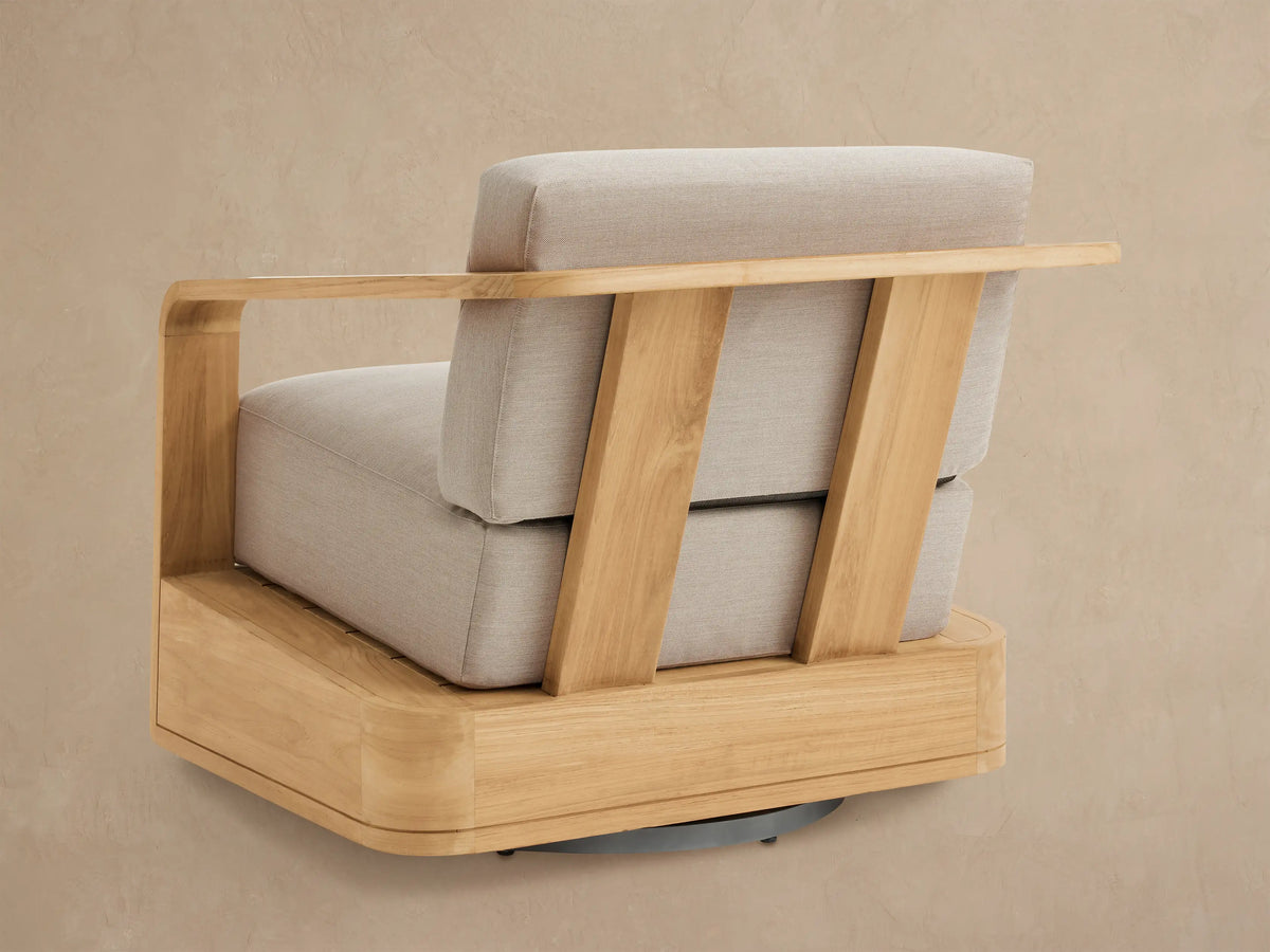 Sonoma Outdoor Teak Swivel Chair. Side view of natural teak frame, light beige cushions, and wooden swivel base.