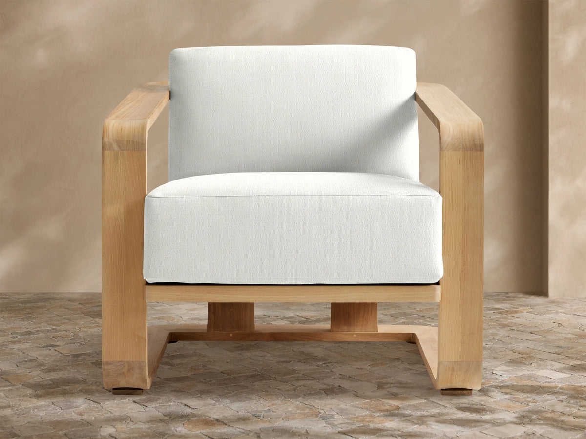 Sonoma Outdoor Teak Lounge Chair with a natural teak frame and thick white Savona Snow cushions, centered on a tiled floor.