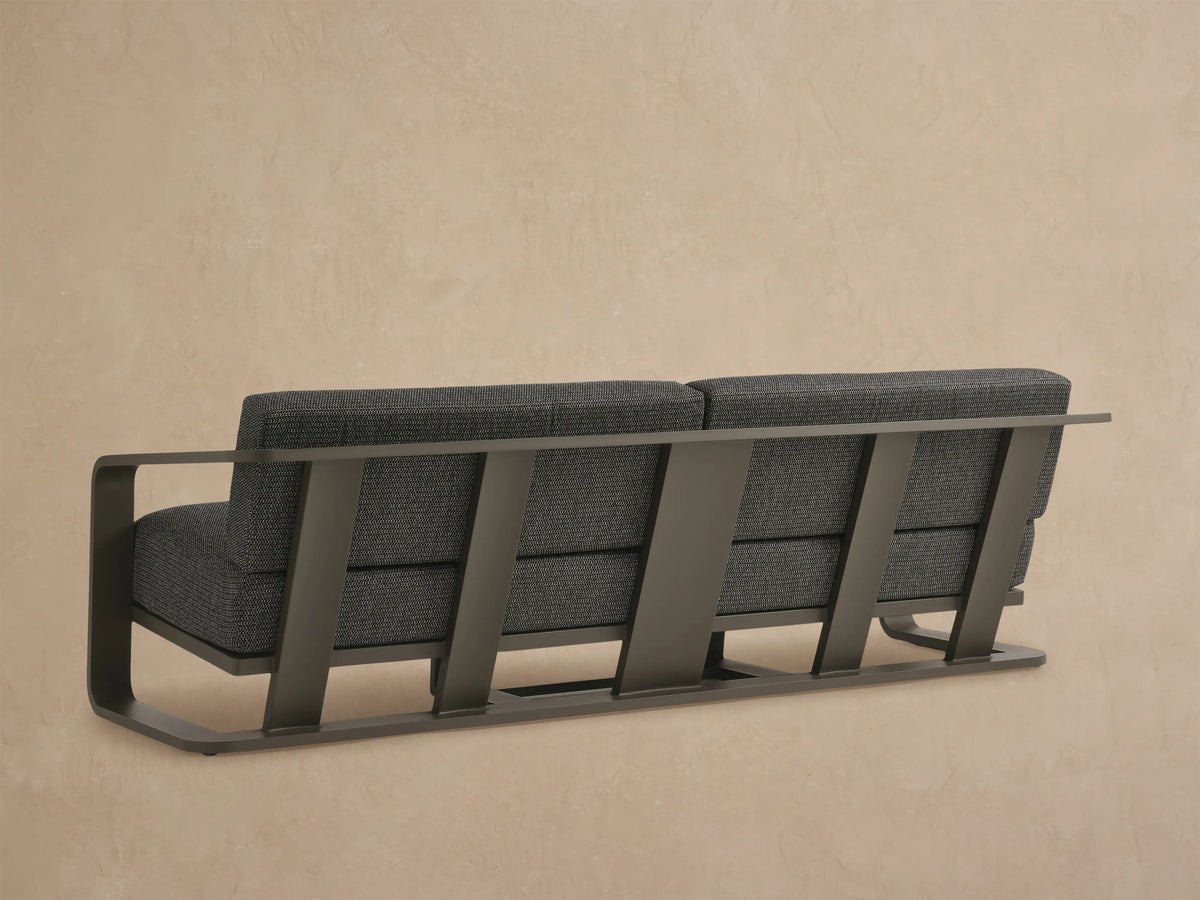 Sonoma Outdoor Aluminum Sofa, close-up. Dark gray textured cushions, multi-tone weave. Bronze aluminum frame and armrest.
