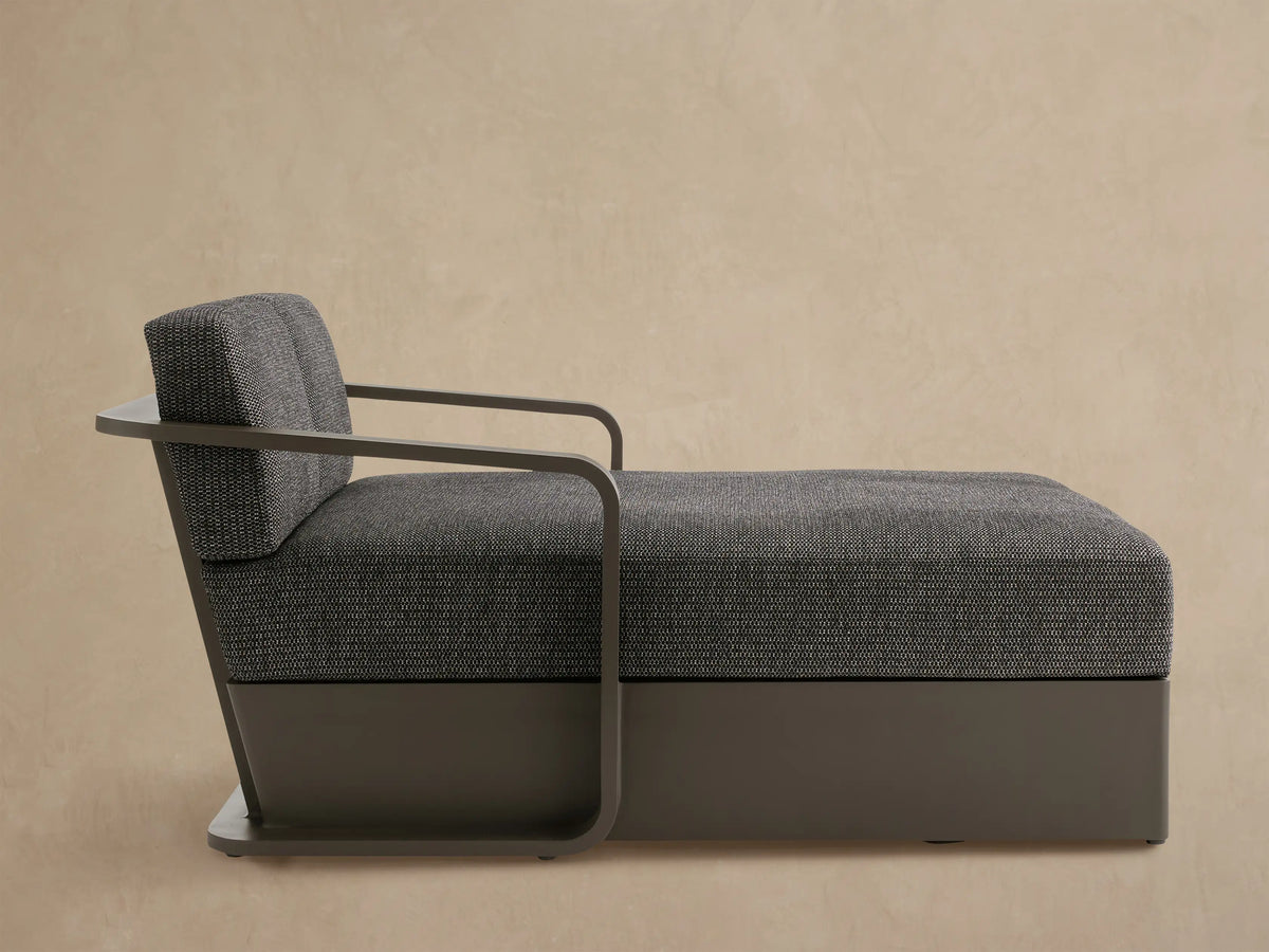 Sonoma Outdoor Aluminum Daybed with dark gray fabric cushions & charcoal frame, angled on a tiled patio against a light wall.
