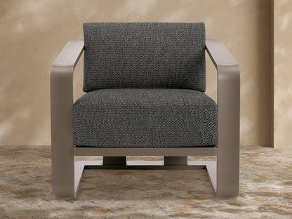 Sonoma Outdoor Aluminum Lounge Chair with dark taupe frame & dark gray textured cushions, viewed from front-right on a stone patio.