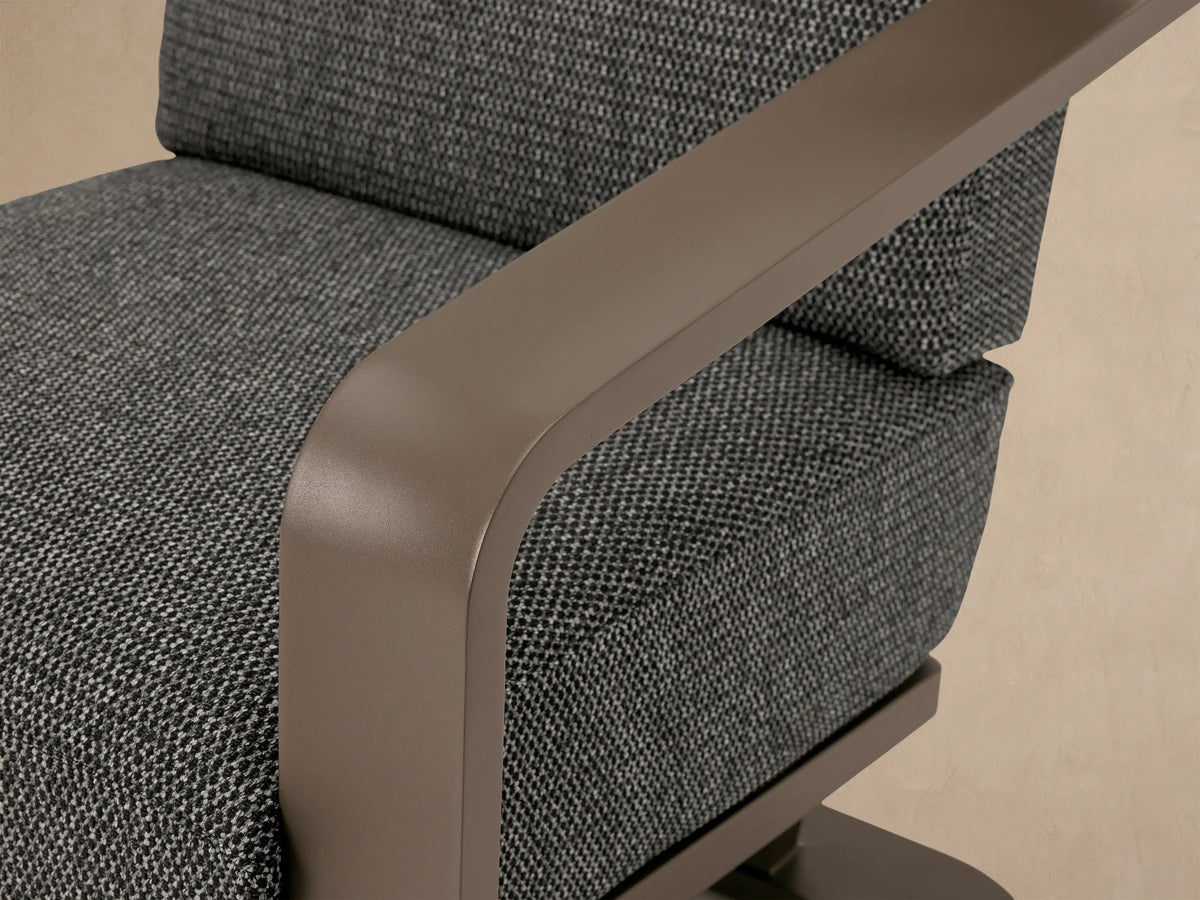 Sonoma Outdoor Aluminum Lounge Chair, front view. Warm gray aluminum frame, dark gray textured cushions on a patio.