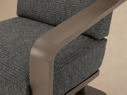 Sonoma Outdoor Aluminum Lounge Chair, front view. Warm gray aluminum frame, dark gray textured cushions on a patio.