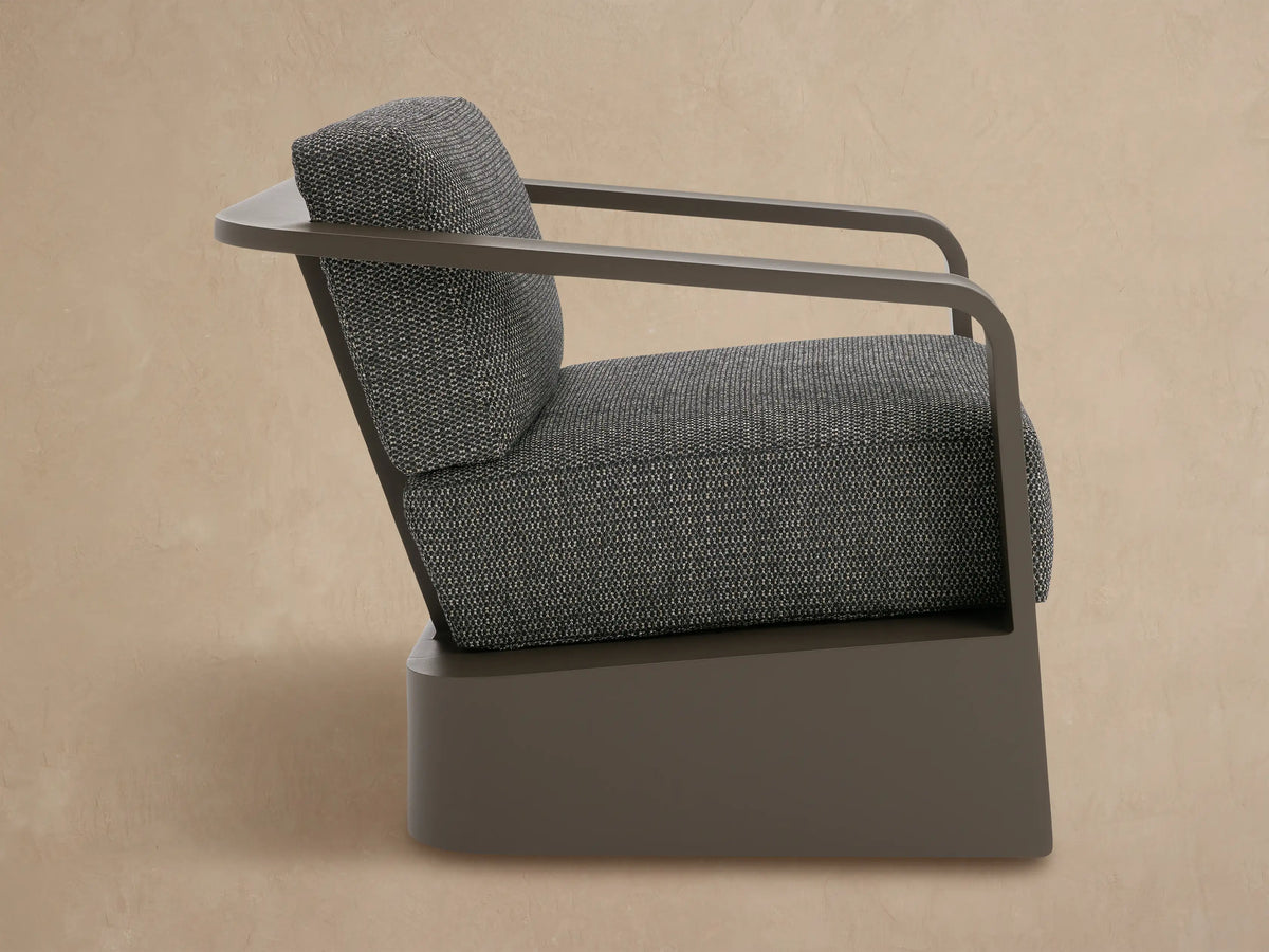 Sonoma Outdoor Swivel Chair with dark gray aluminum frame and speckled gray cushions, angled rear view.