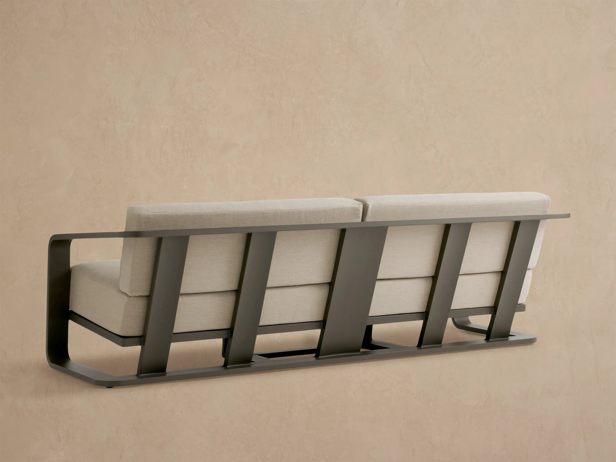 Sonoma Outdoor Aluminum Sofa. Close-up of bronze-toned aluminum arm and textured light beige cushions.