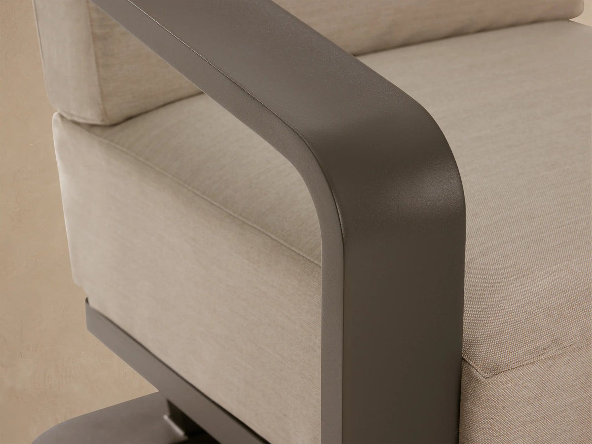 Sonoma Outdoor Aluminum Lounge Chair, front view, dark gray U-shaped frame, light beige seat & back cushions, on stone patio.