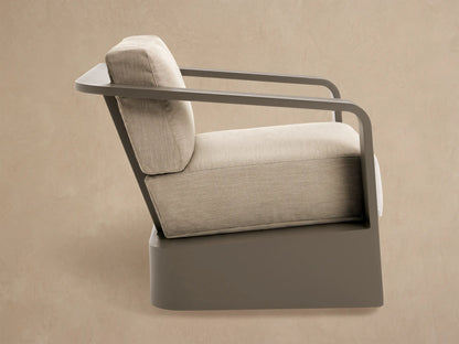 Back view of Sonoma Outdoor Aluminum Swivel Chair. Dark aluminum frame with broad vertical slats and thick light beige cushions.
