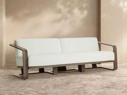 Sonoma Outdoor Aluminum Sofa, front. Dark gray aluminum frame, two thick Savona Snow white cushions on stone patio.
