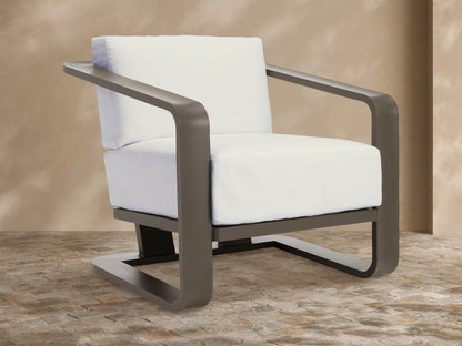 Modern dark gray aluminum Sonoma Outdoor Lounge Chair with thick white Savona Snow cushions, angled right on a tiled patio.
