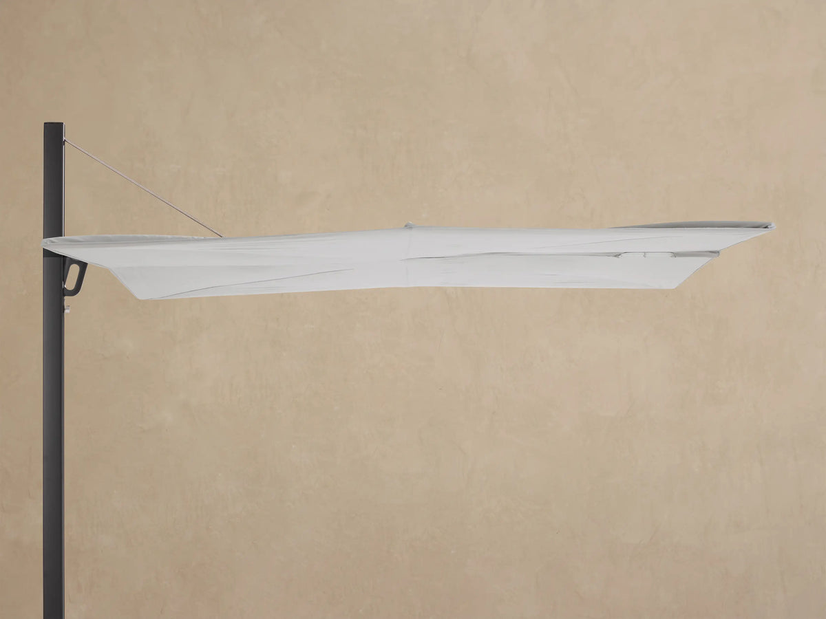 Close-up of Spectra Outdoor Square Umbrella showing its dark gray aluminum frame and articulating arm connected to a light gray canopy.