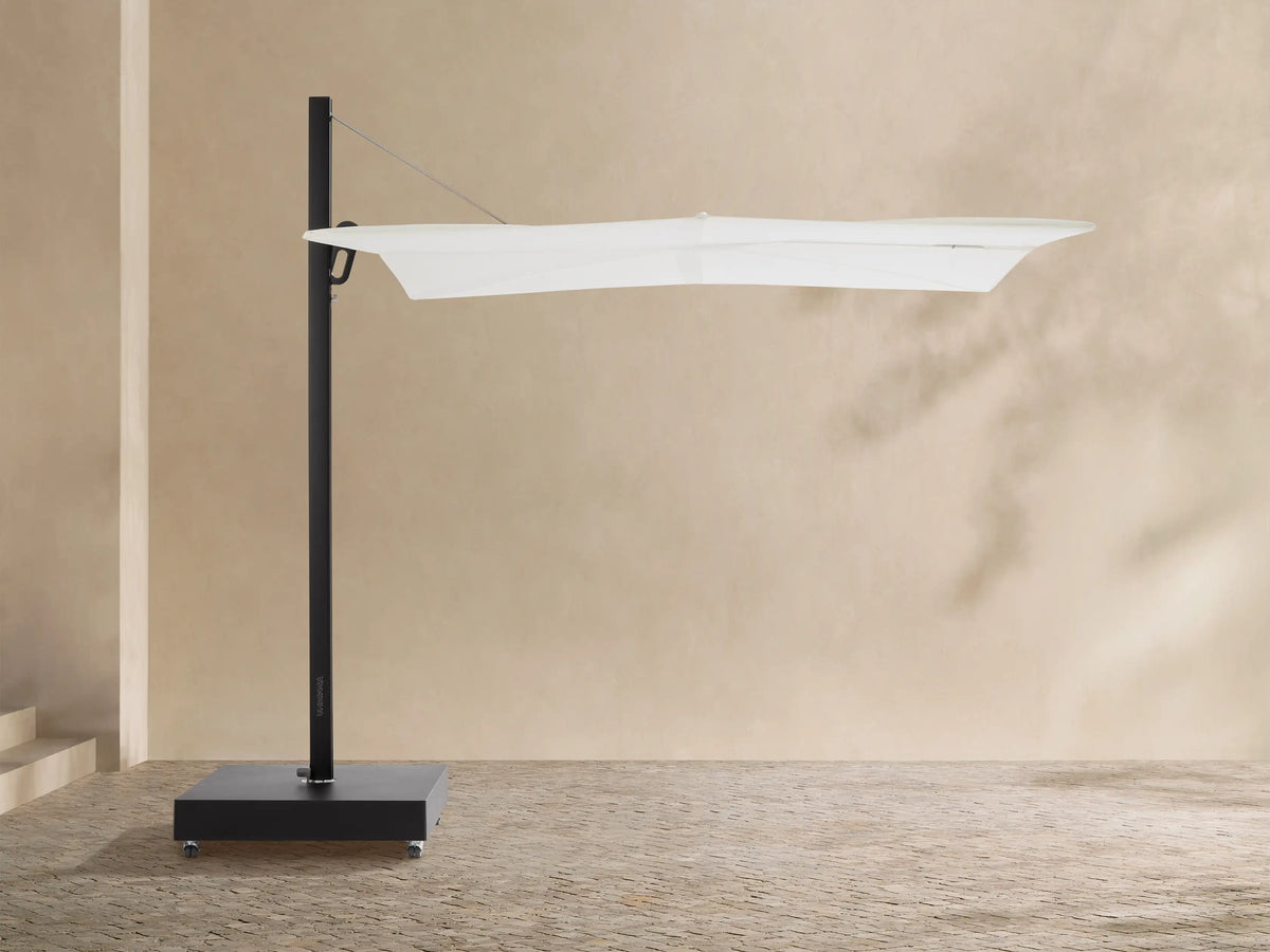 Spectra Outdoor Umbrella with white horizontal closed canopy, black pole, and mobile square base on a textured patio.