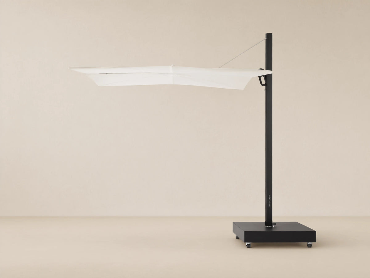 Spectra Outdoor Umbrella with white horizontal closed canopy, black pole, and mobile square base on a textured patio.