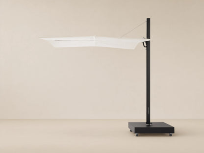 Spectra Outdoor Umbrella with white horizontal closed canopy, black pole, and mobile square base on a textured patio.