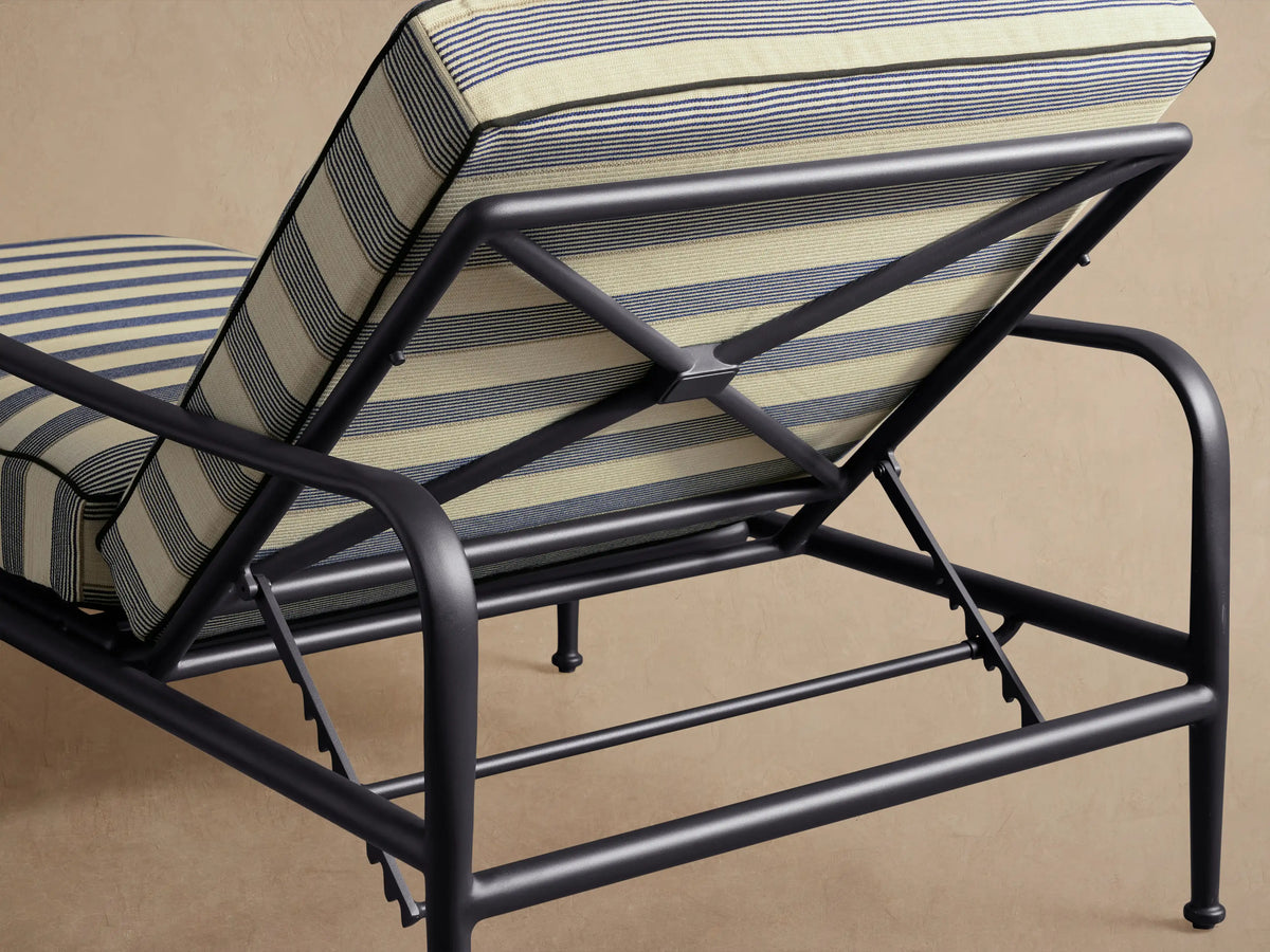 Front view of black Surrey Outdoor Chaise with off-white cushions and dark navy blue stripes, backrest inclined.