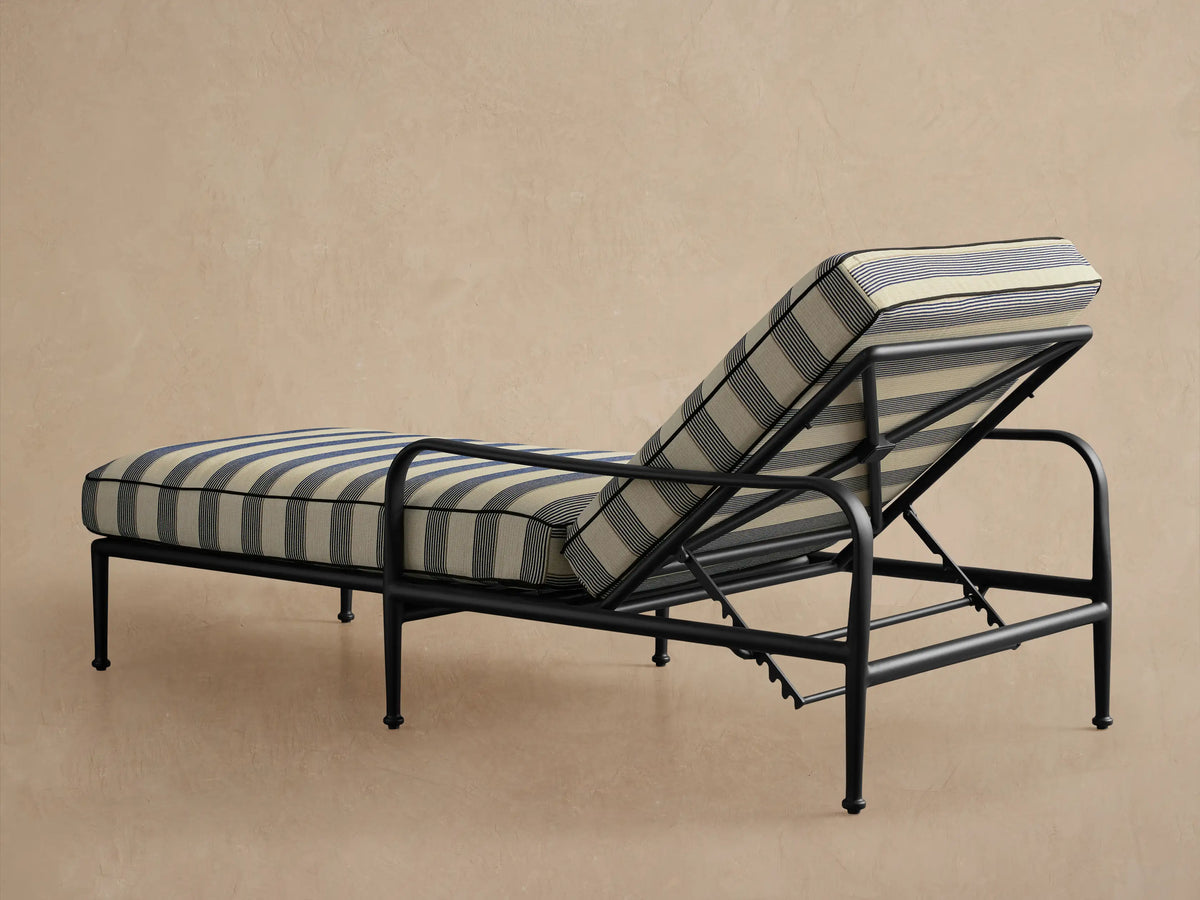 Close-up of the adjustable back of a Surrey Outdoor Chaise, with a dark gray metal frame and blue and off-white striped cushion.