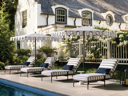 Side view of the Surrey Outdoor Chaise, featuring a black aluminum frame and navy and cream striped cushions with an adjustable back.