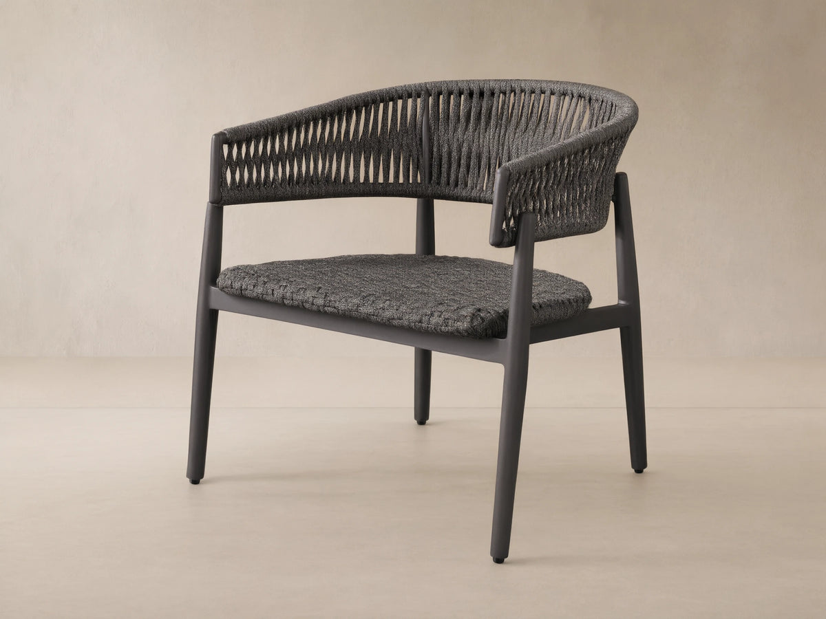 Talia Outdoor Aluminum Lounge Chair with a dark gray woven rope back and seat, on a powder-coated aluminum frame, angled right.