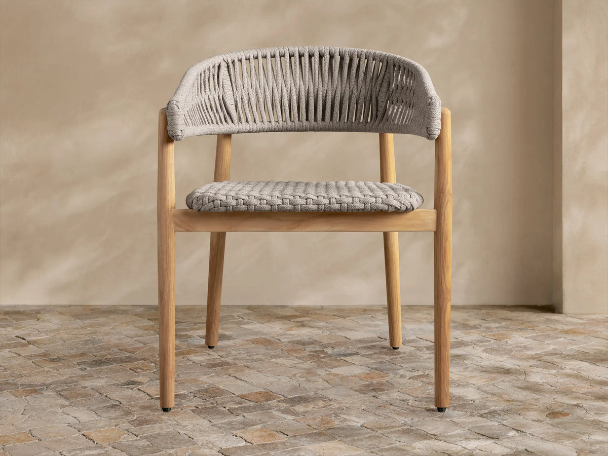 Light gray Talia Outdoor Collection Cover, tailored over a chair, front view, with a V-seam and central vertical slit.