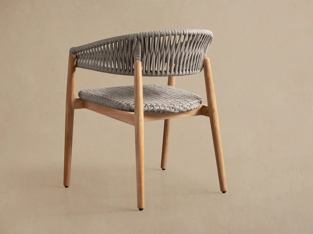 Talia Outdoor Teak Dining Chair, angled close-up of natural teak frame with handwoven gray Performance Weave rope seat and back.