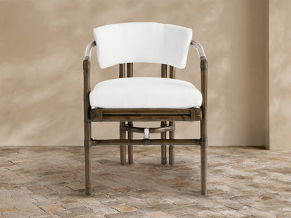 White water-repellent replacement seat and back cushions, on a dark rattan outdoor chair, centered against a beige wall & tiled patio.