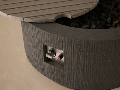 Wilmar Round Propane Fire Pit: Dark gray textured concrete, round, with a slatted lid, on a light beige background.