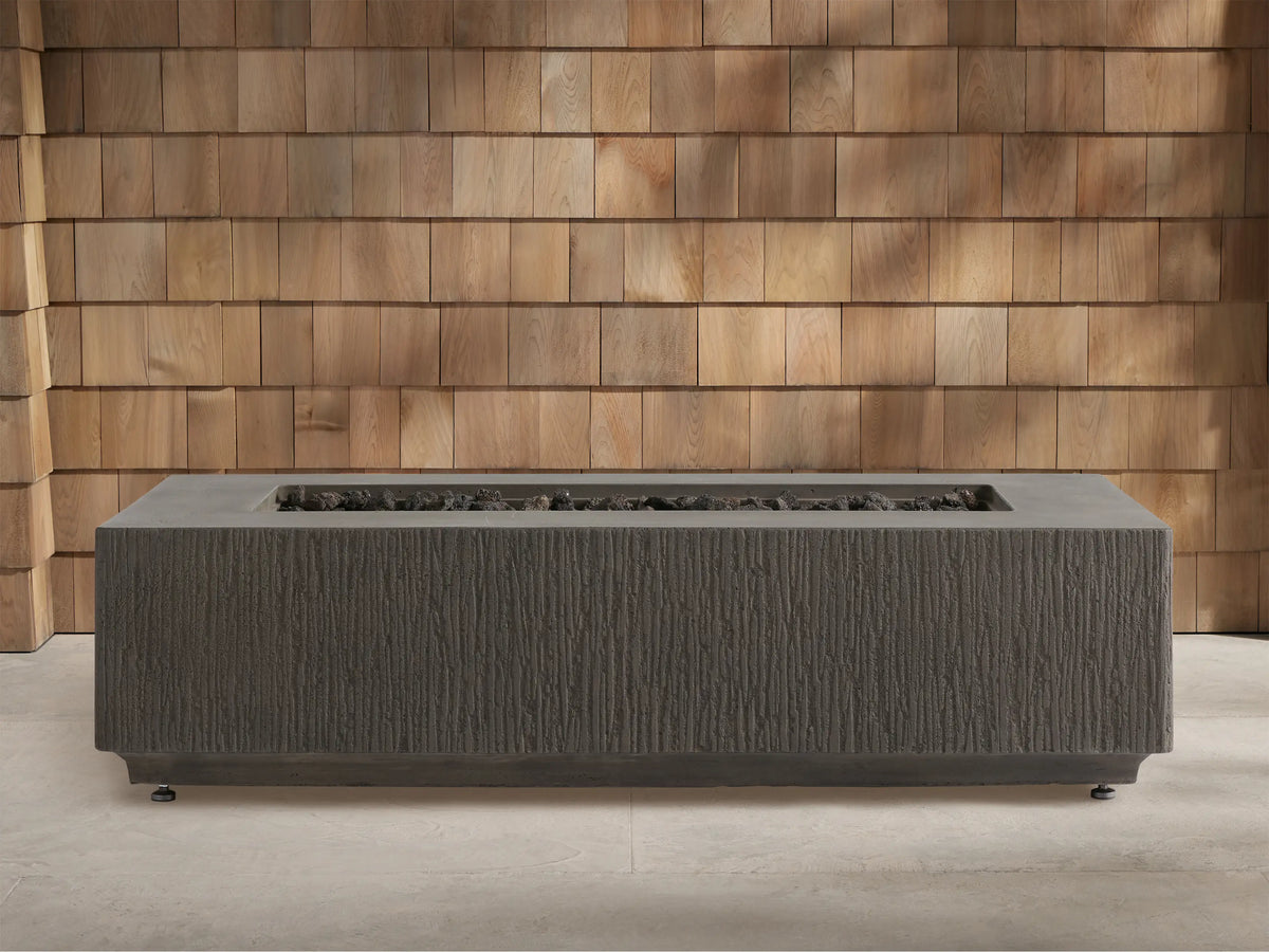 Wilmar Rectangular Propane Fire Pit, dark gray textured concrete, with bright flames rising from black lava rocks.