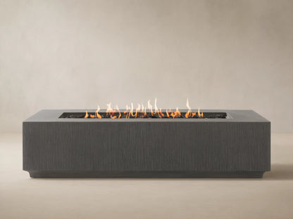 Wilmar Rectangular Propane Fire Pit, dark gray textured concrete, with bright flames rising from black lava rocks.