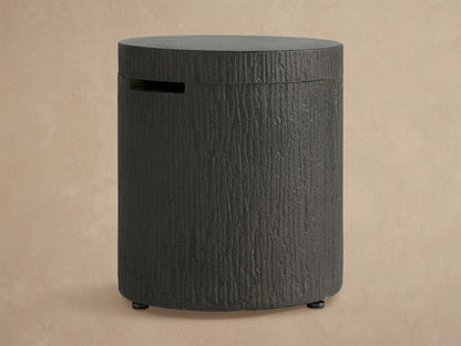 Cylindrical dark gray concrete Wilmar Fire Pit Tank Cover with bark-like texture, flat top, and horizontal slot.
