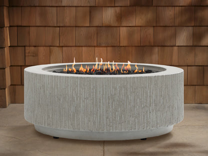 Wilmar Round Propane Fire Pit in Fog Chiseled, light gray concrete with textured sides, flames burning in black lava rocks.