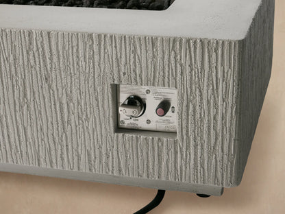 Rectangular Wilmar fire pit, textured light gray concrete with a black slatted top cover, shown frontally against a beige wall.