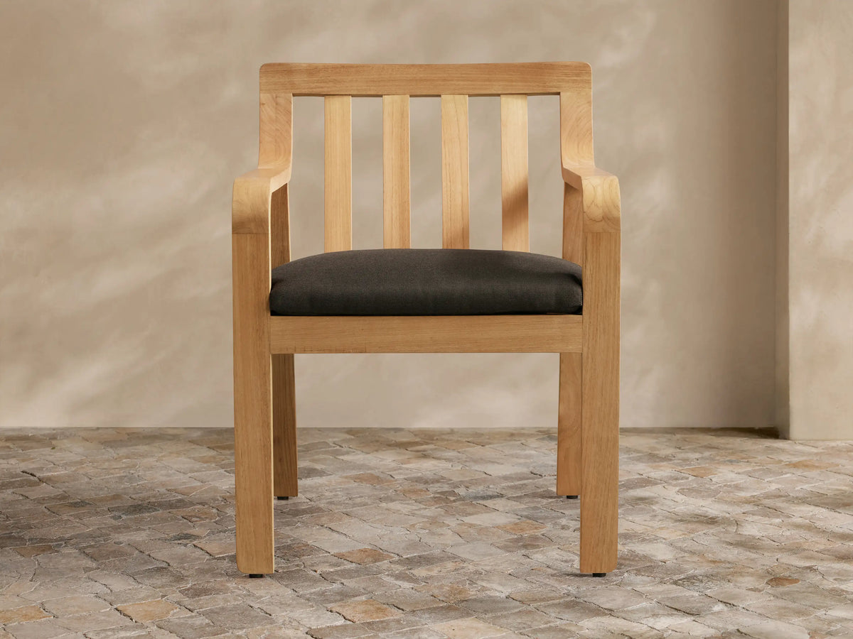 Light grey Zoe Outdoor Collection Cover, tailored for a chair, with a V-seam & vertical front opening, on a stone patio.