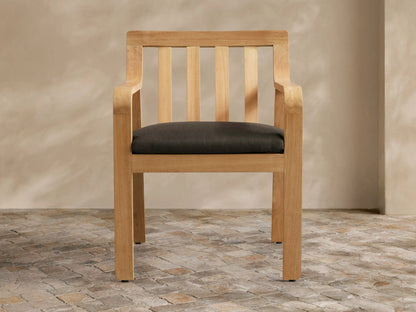 Light grey Zoe Outdoor Collection Cover, tailored for a chair, with a V-seam & vertical front opening, on a stone patio.