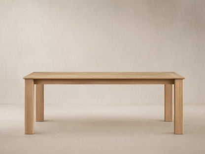 Zoe Outdoor Dining Table: Rectangular, golden-toned natural teak wood with sturdy legs, on a patterned patio floor.
