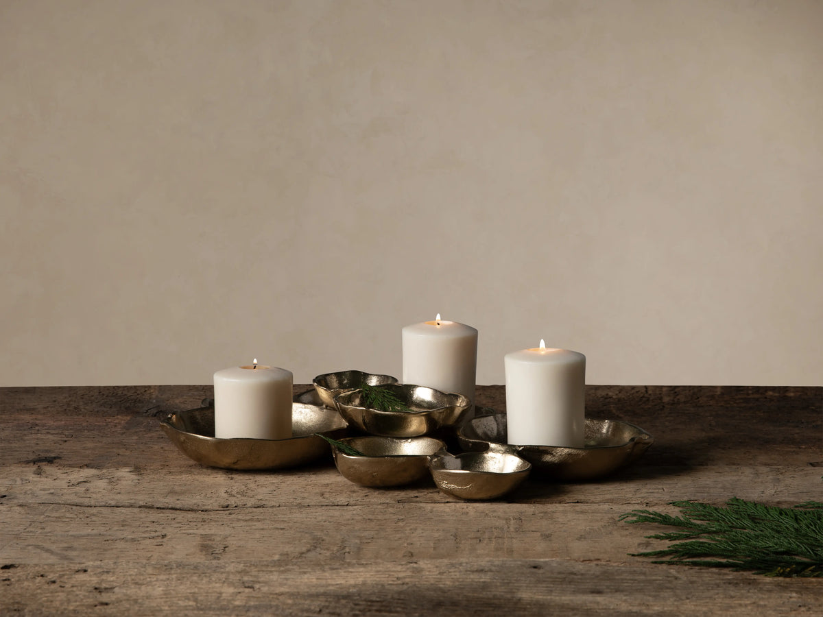Collection of dark gold Klasa platters & bowls on wood. Large platter with figs, others with olives & grapes.