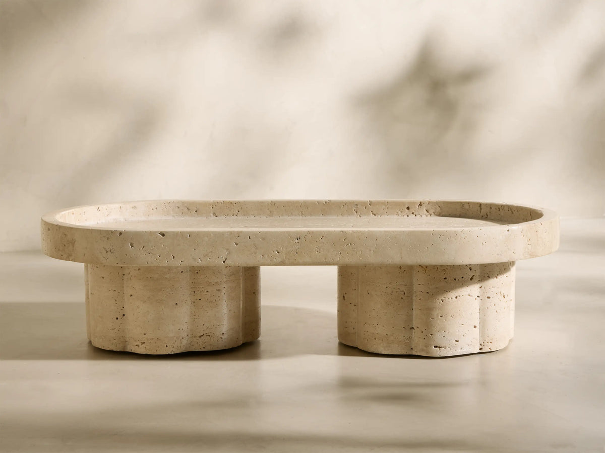 Front view of the beige and ivory-toned Sylvaine Footed Tray with an oval top and two scalloped cylindrical feet.