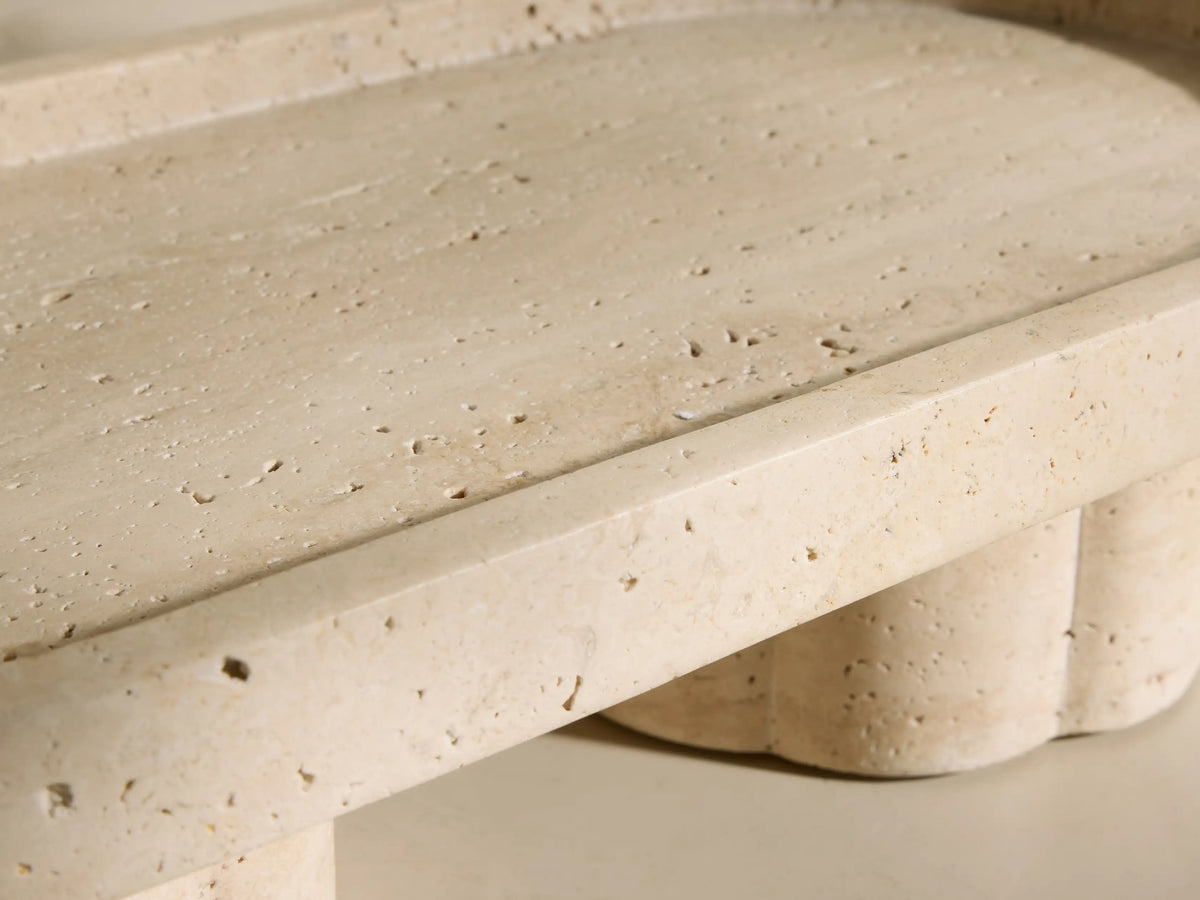 Front view of the beige and ivory-toned Sylvaine Footed Tray with an oval top and two scalloped cylindrical feet.