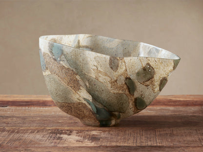 Andromeda Organic Bowl, mouth-blown glass with organic shape, swirling earthy blue, green, brown, and gray patterns on wood.