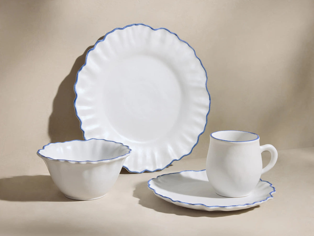 Capuchos Dinnerware: White matte ruffled plate, cereal bowl, mug on plate, all with blue hand-painted rims.