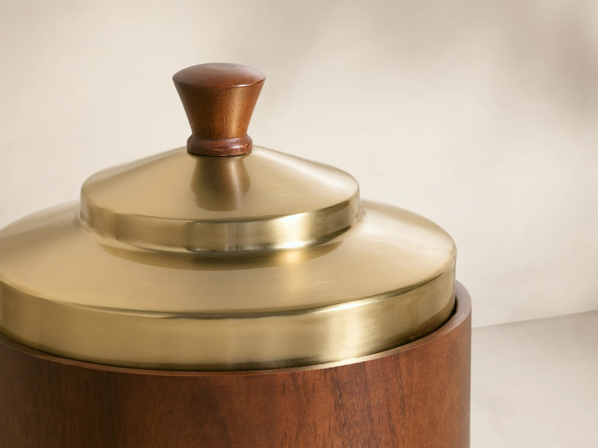 Front view of the brown wooden Errol Ice Bucket, with a brass lid and small wooden knob. Lid rests ajar, revealing a stainless steel interior.