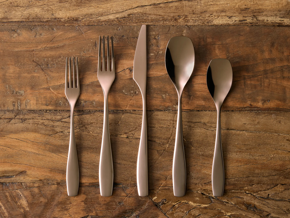 Esma Five Piece Place Setting with chocolate finish includes two forks, a knife, and two spoons on a wooden surface.