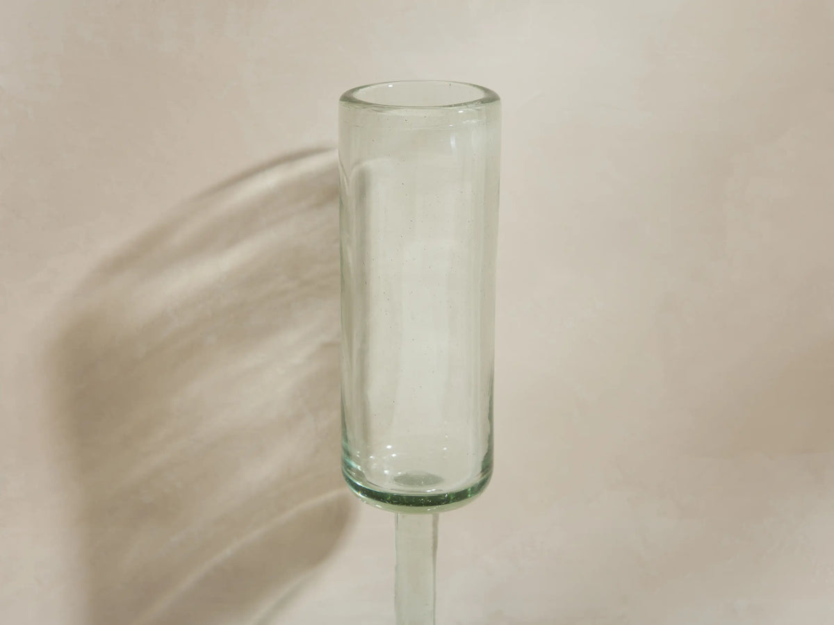 Four handblown Granada Champagne Glasses made from recycled glass. One is filled with champagne, three are empty.