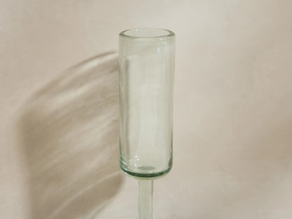 Four handblown Granada Champagne Glasses made from recycled glass. One is filled with champagne, three are empty.