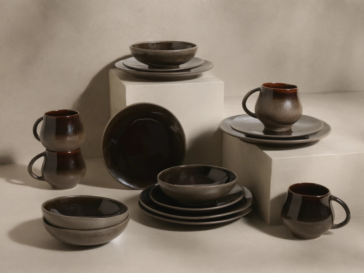 Chocolate and mocha Hearthline Dinnerware With Cereal Bowls (Set of 16), featuring reactive glaze mugs, bowls, and plates.