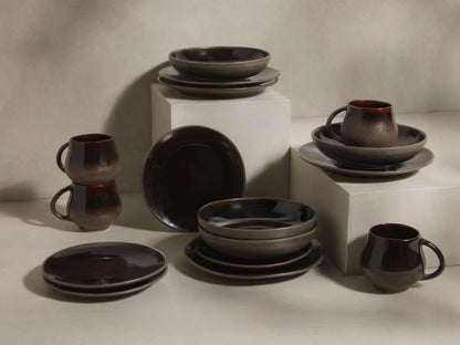 Full display of the chocolate and mocha Hearthline Dinnerware With Pasta Bowls (Set of 16) with reactive glaze.