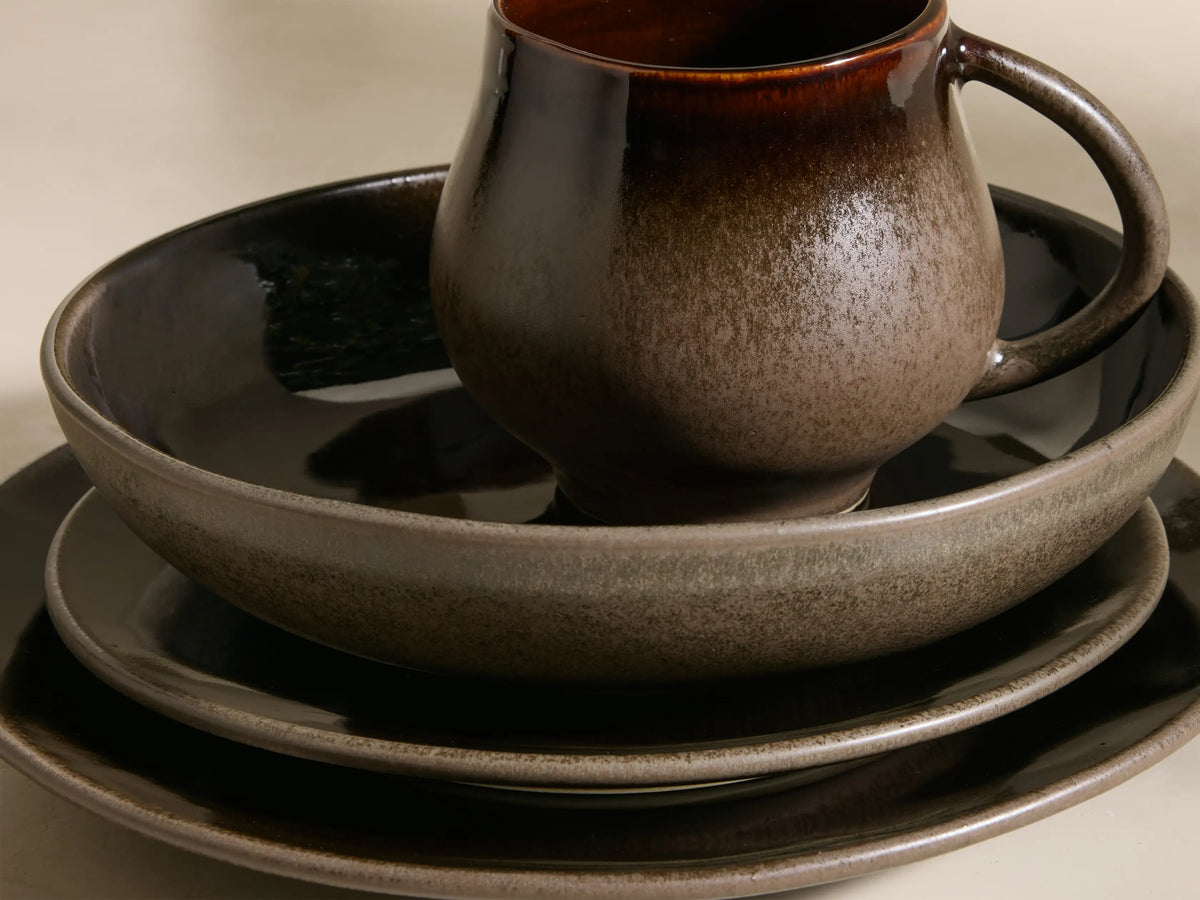 Full display of the chocolate and mocha Hearthline Dinnerware With Pasta Bowls (Set of 16) with reactive glaze.